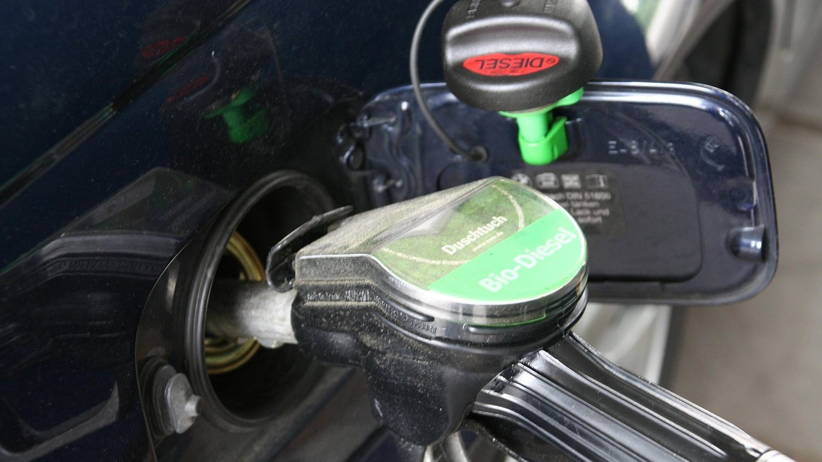 Tankovacia pištoľ v hrdle nádrže auta vedľa uzáveru s nápisom Diesel