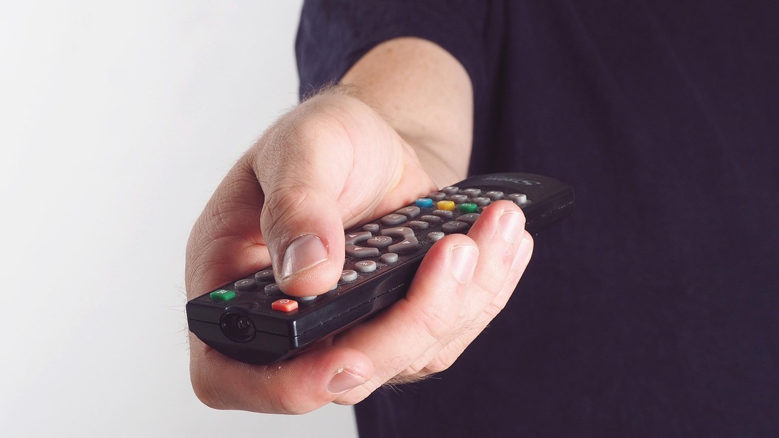 Ruka drží diaľkový ovládač od televízora