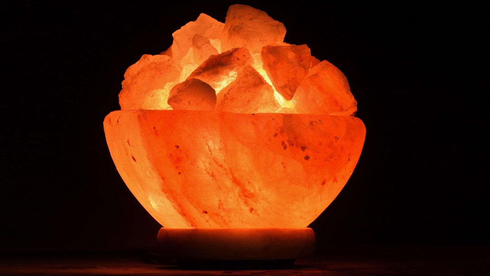 Rozsvietená soľná lampa v tvare misky s kúskami soli