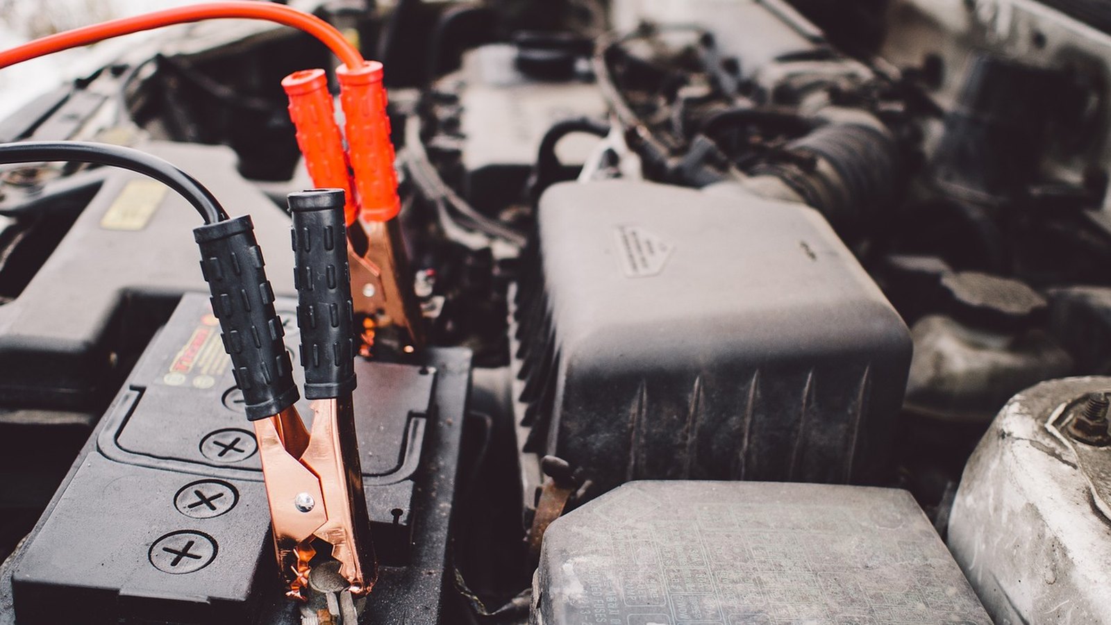 Štartovacie káble pripojené na póly autobatérie v motorovom priestore