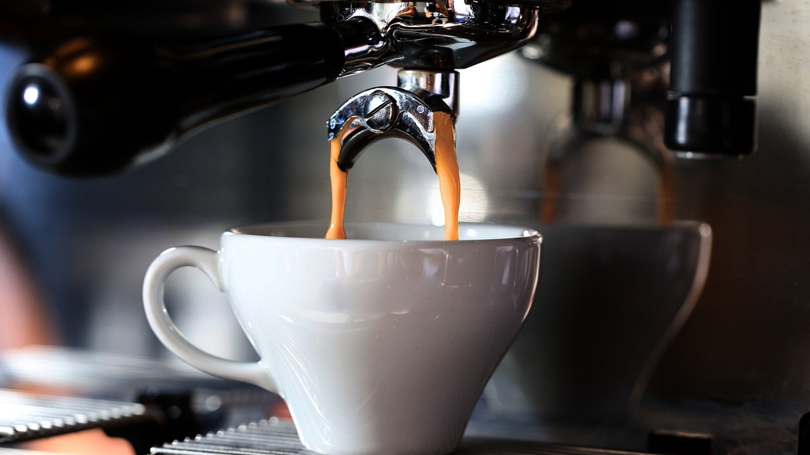 Espresso tečie z kávovaru do bielej šálky
