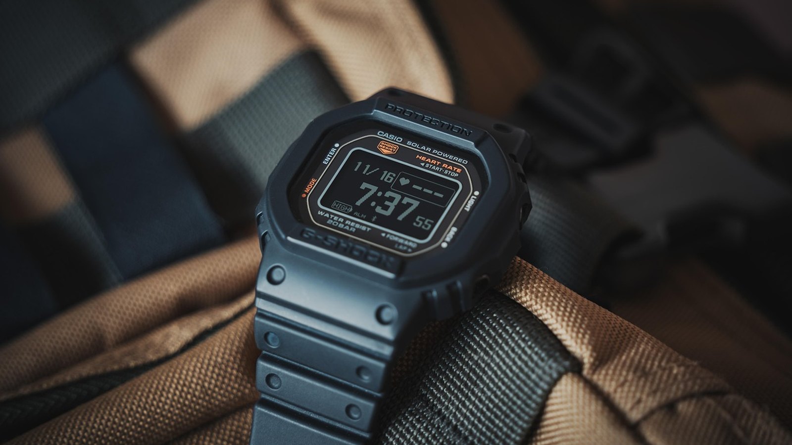 Digitálne hodinky G-Shock položené na batohu